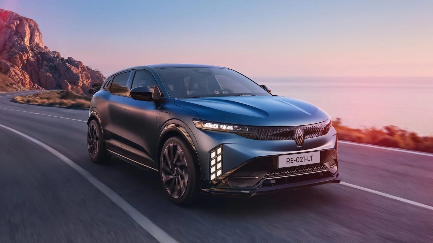 Renault Megane E-Tech eléctrico en una carretera costera al atardecer