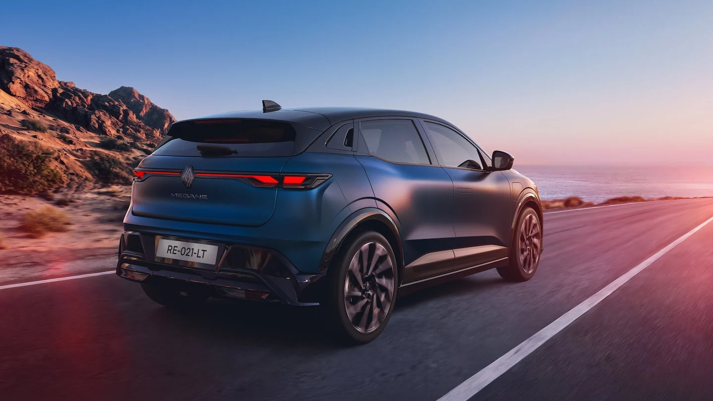 Renault Megane E-Tech visto desde atrás en una carretera costera al atardecer