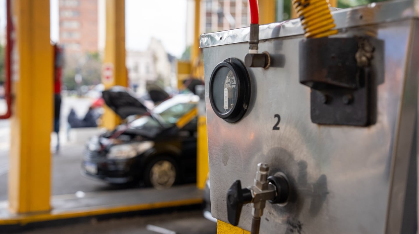 Estación de GNC con medidor y vehículo en espera de servicio