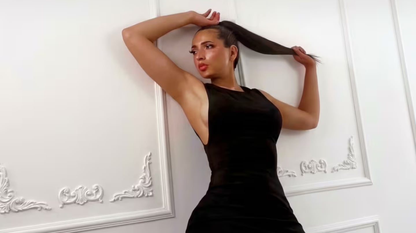 Modelo Natalia Villalba posando con un vestido negro frente a una pared decorativa