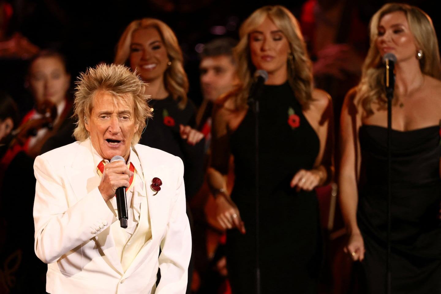 Rod Stewart cantando en un concierto con coristas en Utah