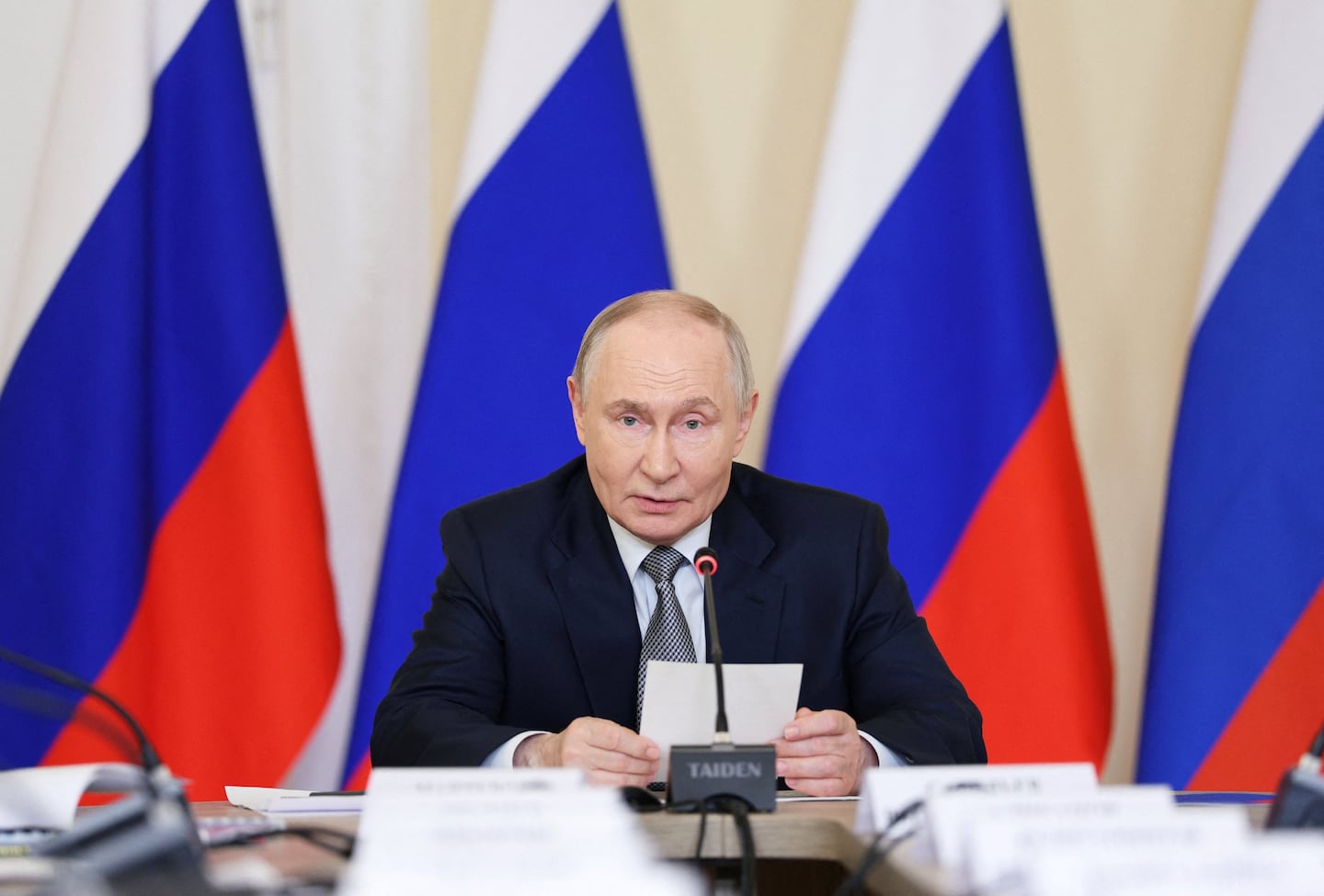 Vladimir Putin durante una reunión con banderas de Rusia de fondo