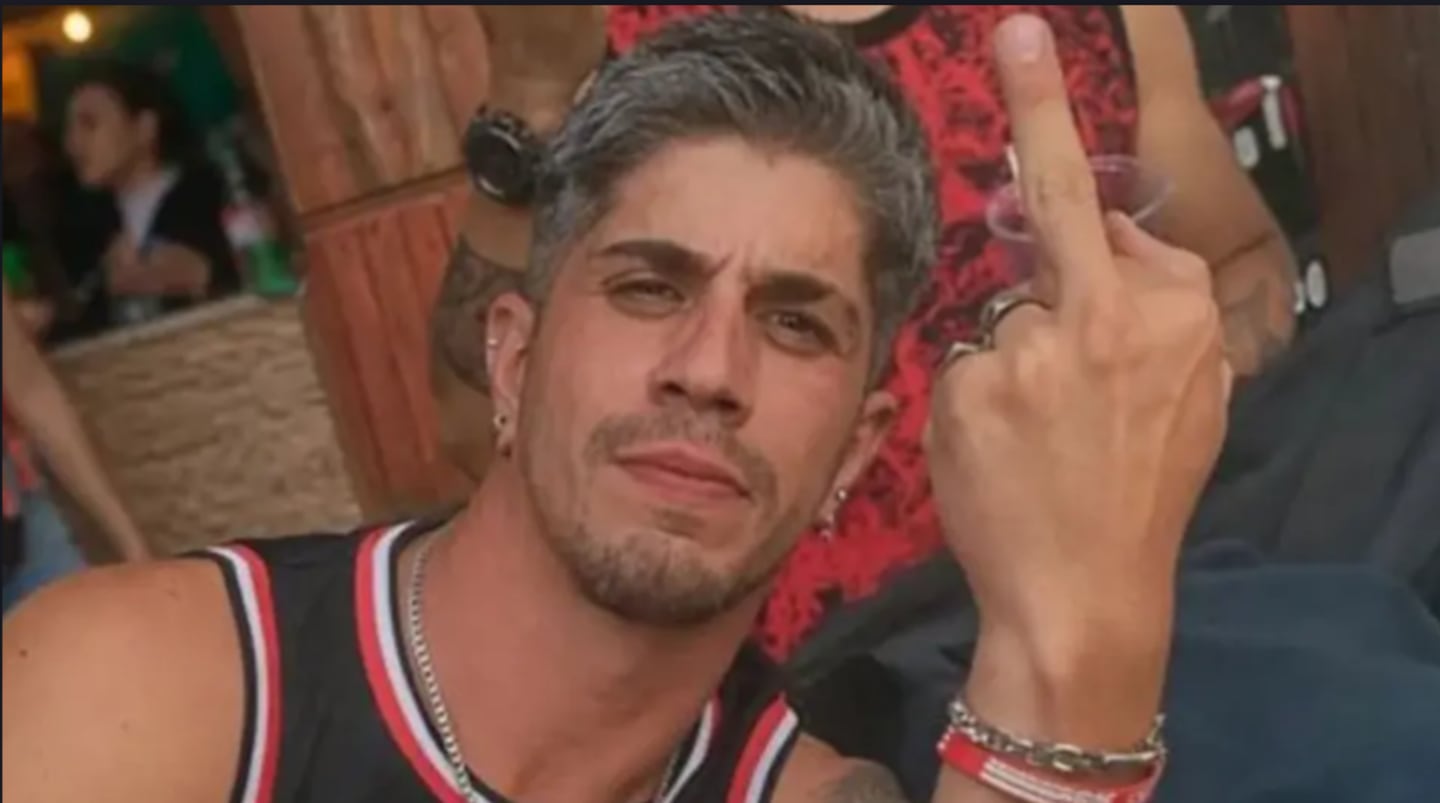 Hombre mostrando el dedo medio en un entorno festivo