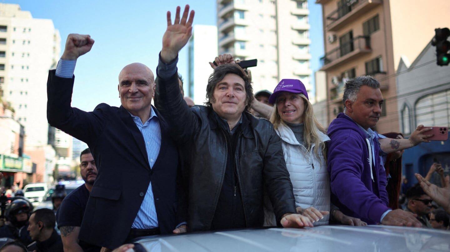 José Luis Espert y su equipo levantan los brazos en un acto público