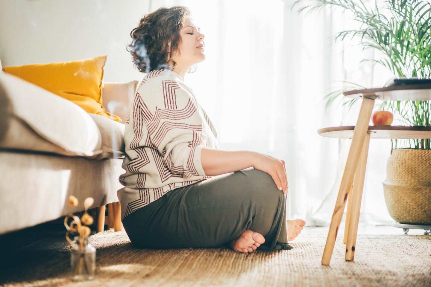 Mujer meditando en un ambiente acogedor para reducir la presión arterial
