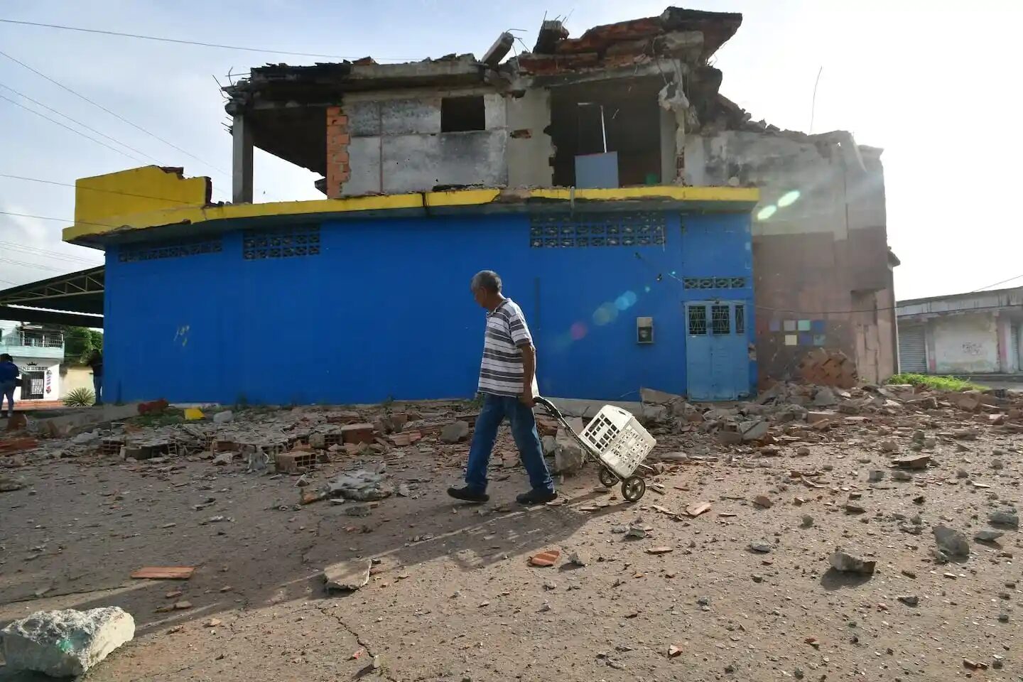 Hombre caminando entre escombros tras un terremoto en Venezuela
