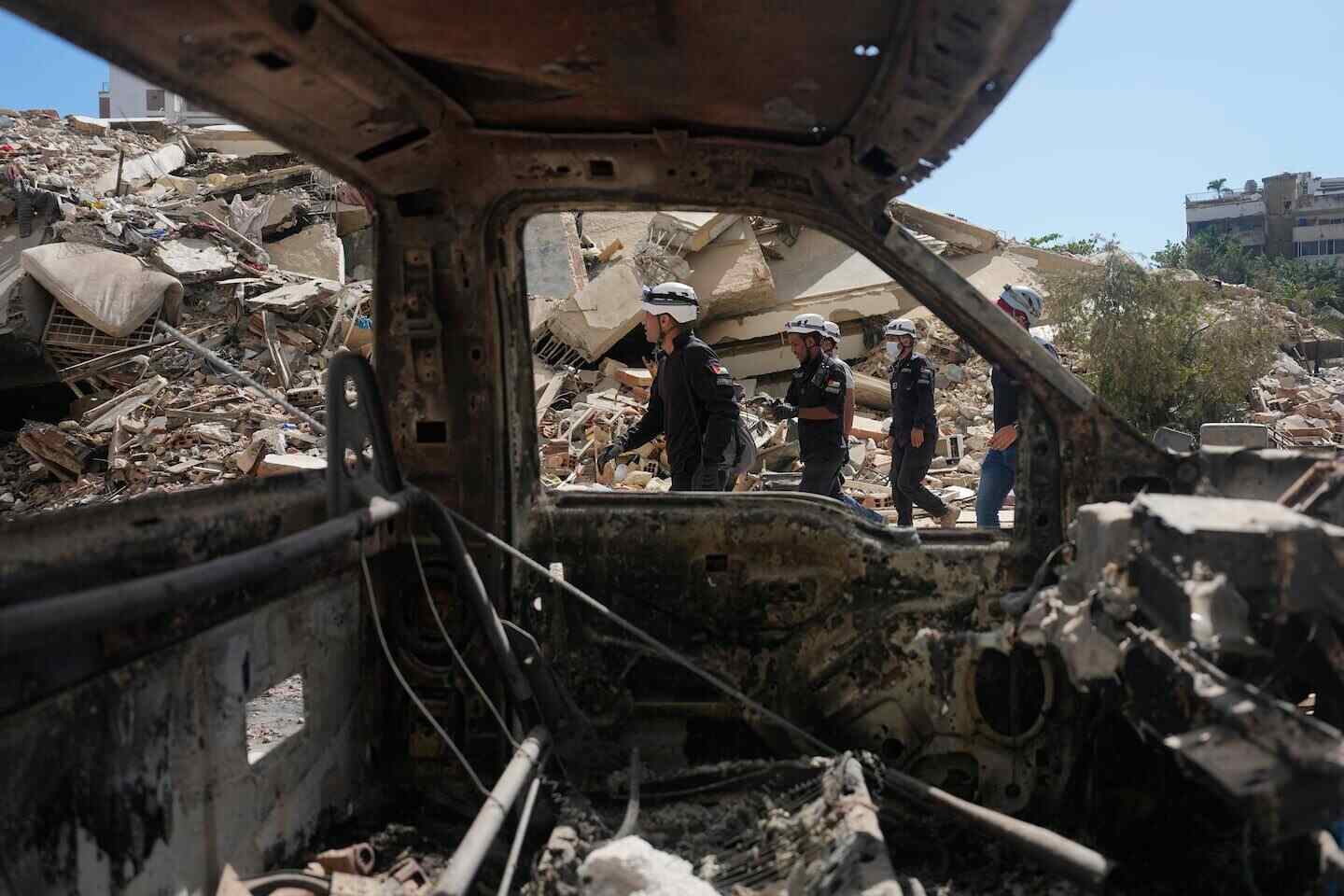 Rescatistas caminan entre escombros de un edificio derrumbado en La Guaira, Venezuela