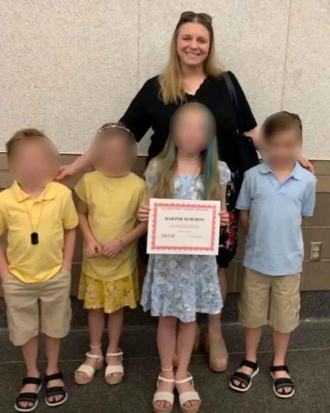 Mujer con cuatro niños en un evento familiar sosteniendo un certificado