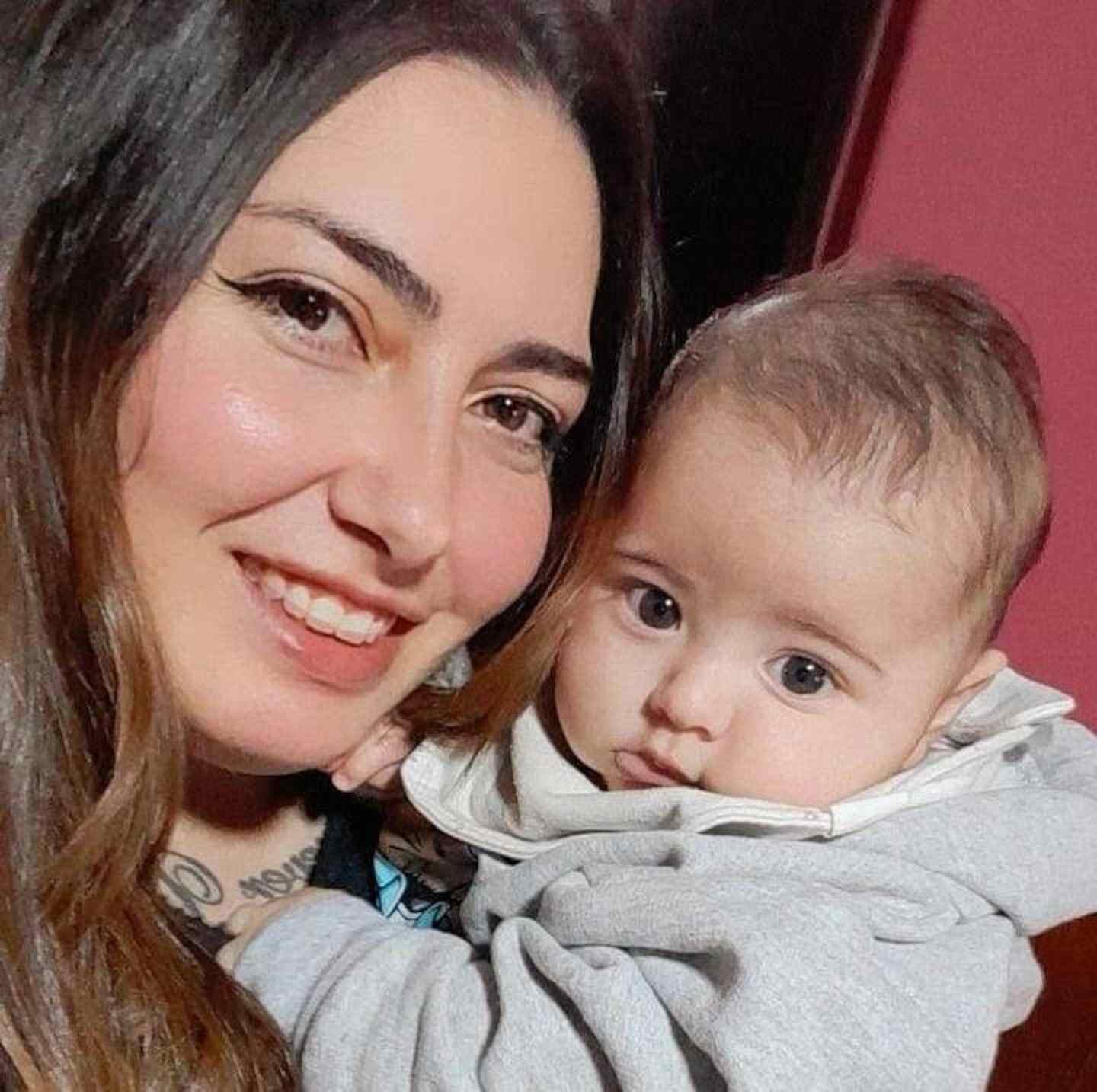 Melina Victoria Acevedo sonríe mientras sostiene a su hijo en brazos