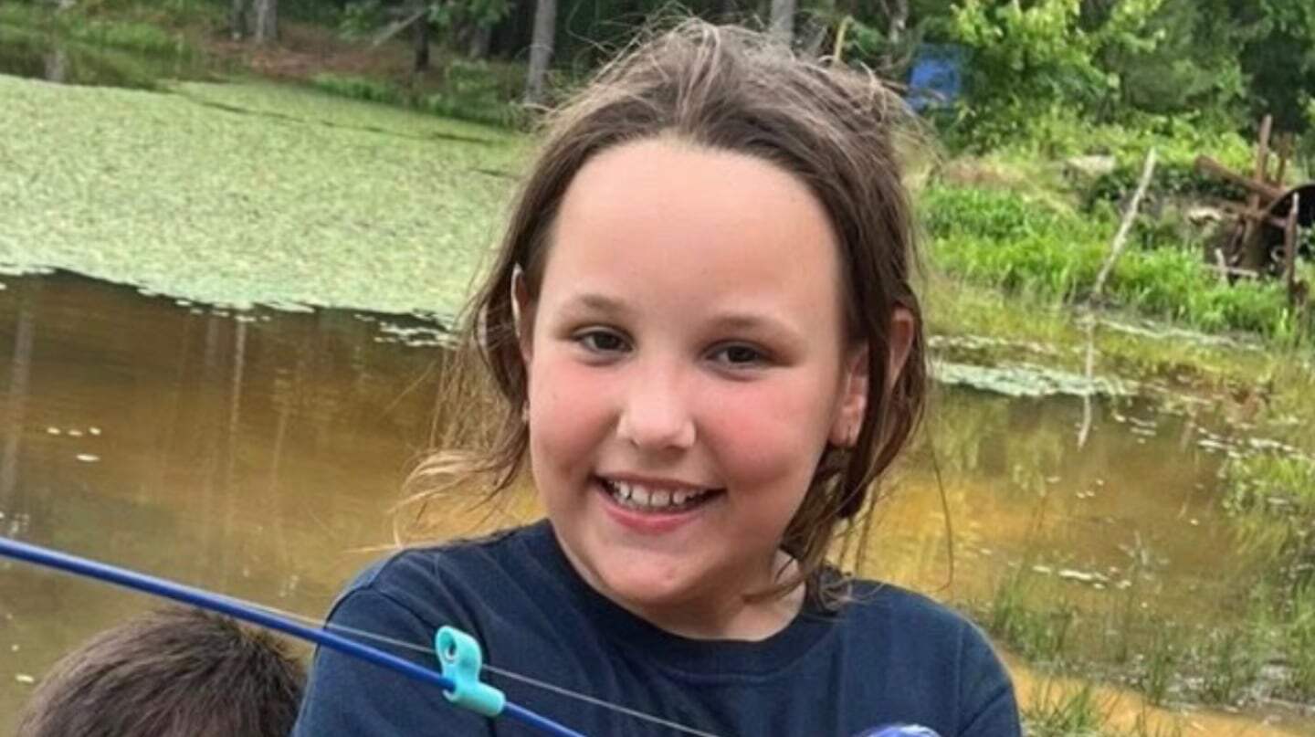 Niña sonriente de ocho años junto a un lago en Oklahoma