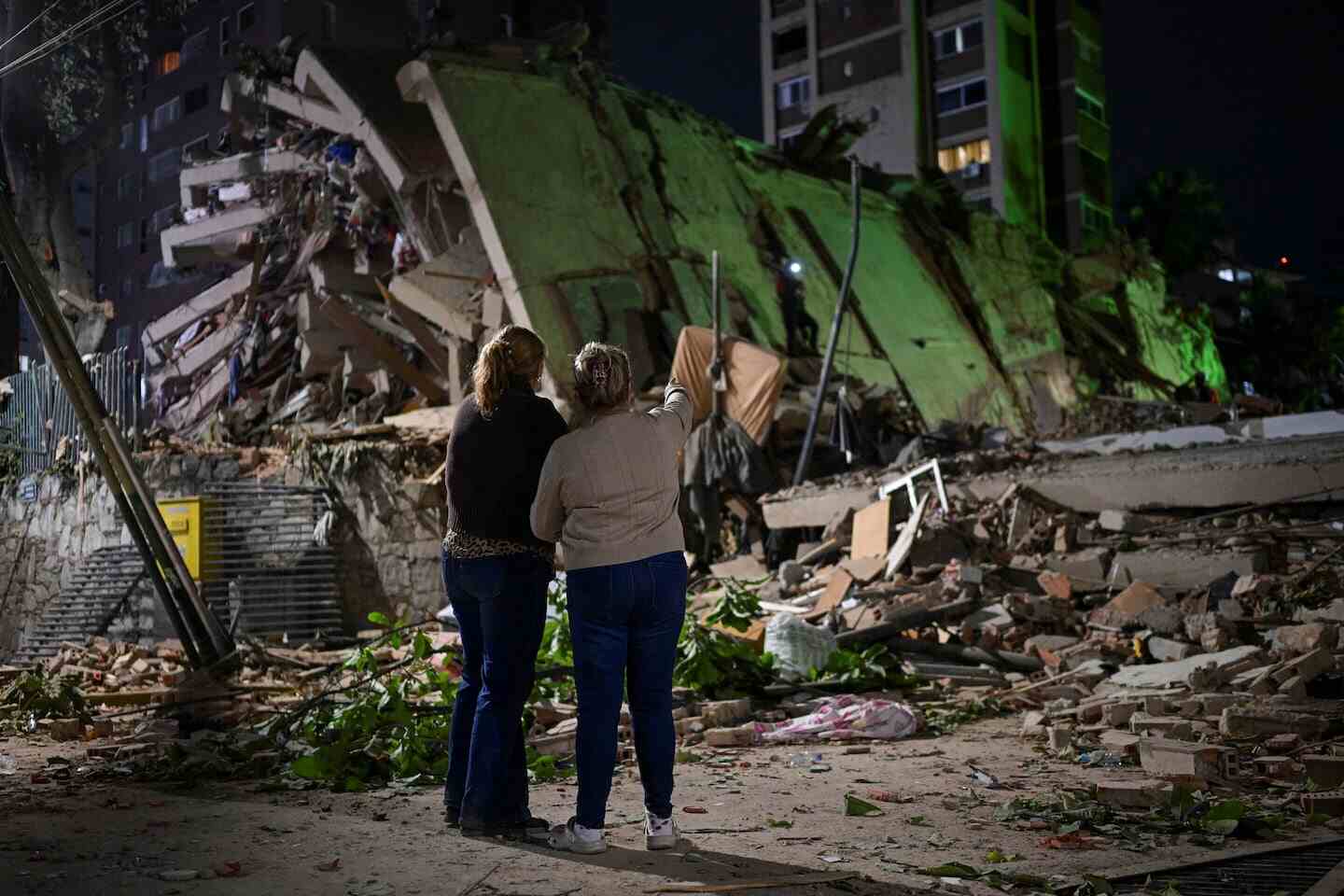 Dos mujeres observan los escombros de un edificio colapsado tras un terremoto en Venezuela