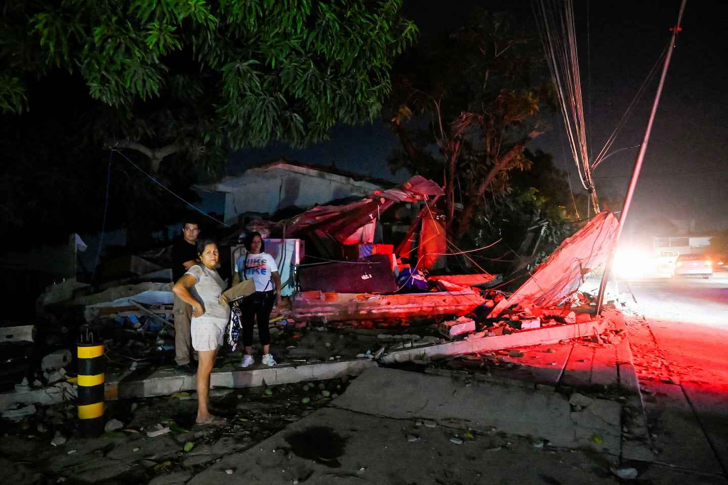 Edificio dañado en Venezuela tras un terremoto, con personas en primer plano