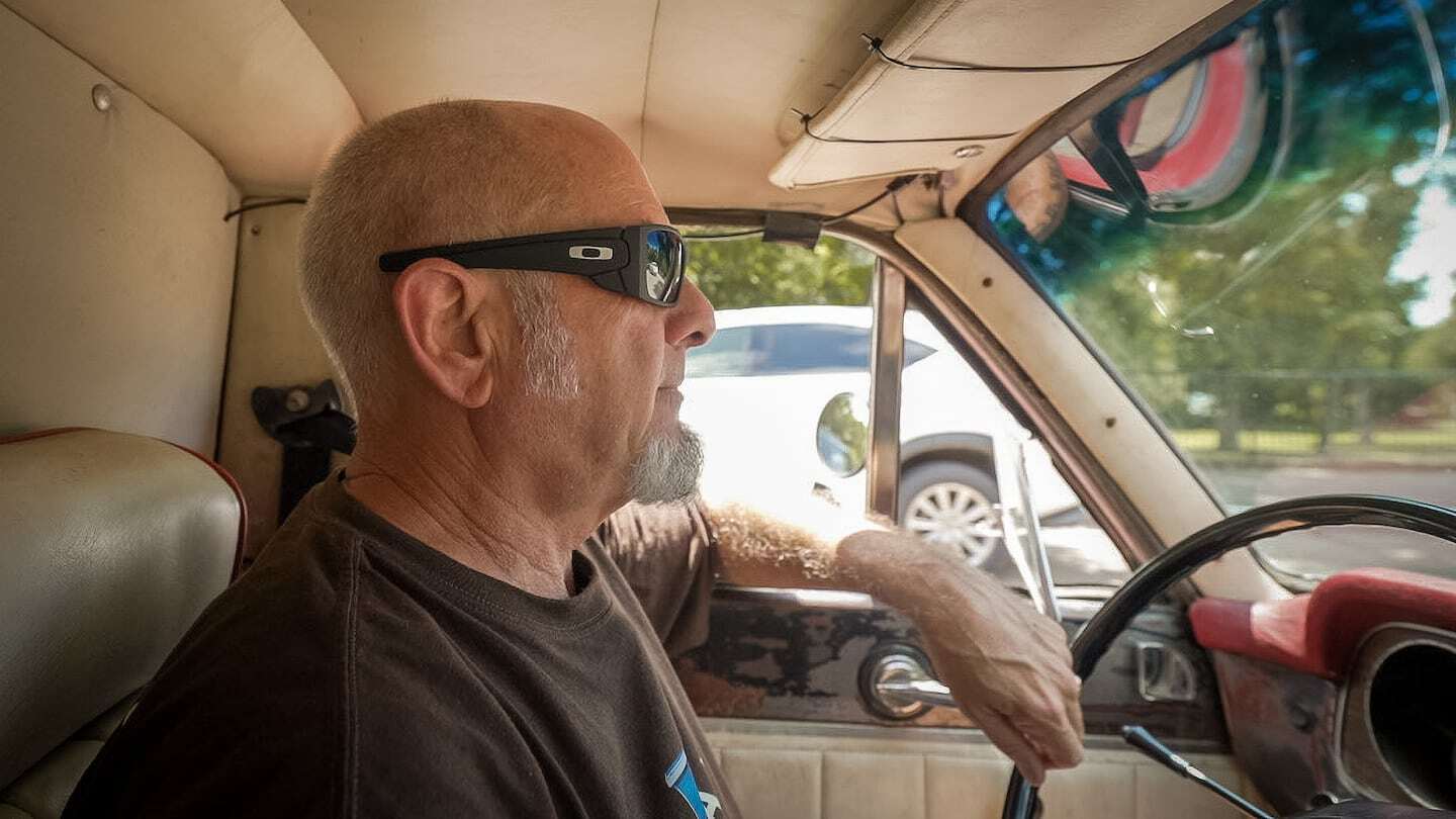 Hombre conduciendo un Ford Ranchero 1977 con gafas de sol