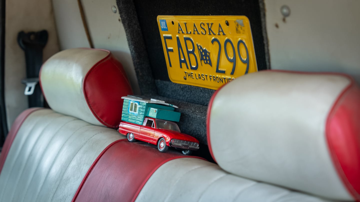 Interior de un Ford Ranchero con un juguete de auto y una placa de matrícula de Alaska