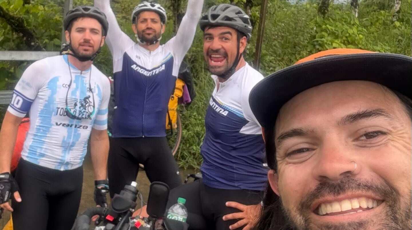 Hinchas argentinos posando sonrientes durante su viaje en bicicleta hacia el Mundial 2026