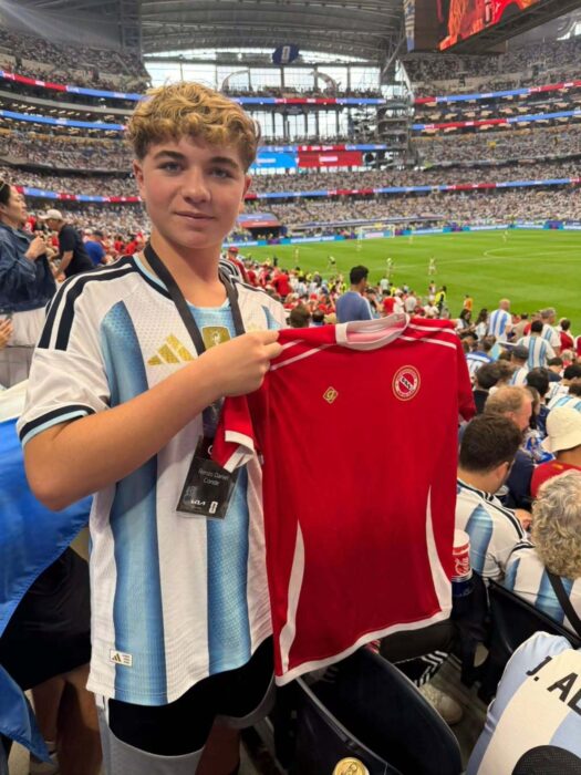 Joven marplatense sostiene una camiseta roja en el estadio durante el Mundial 2026