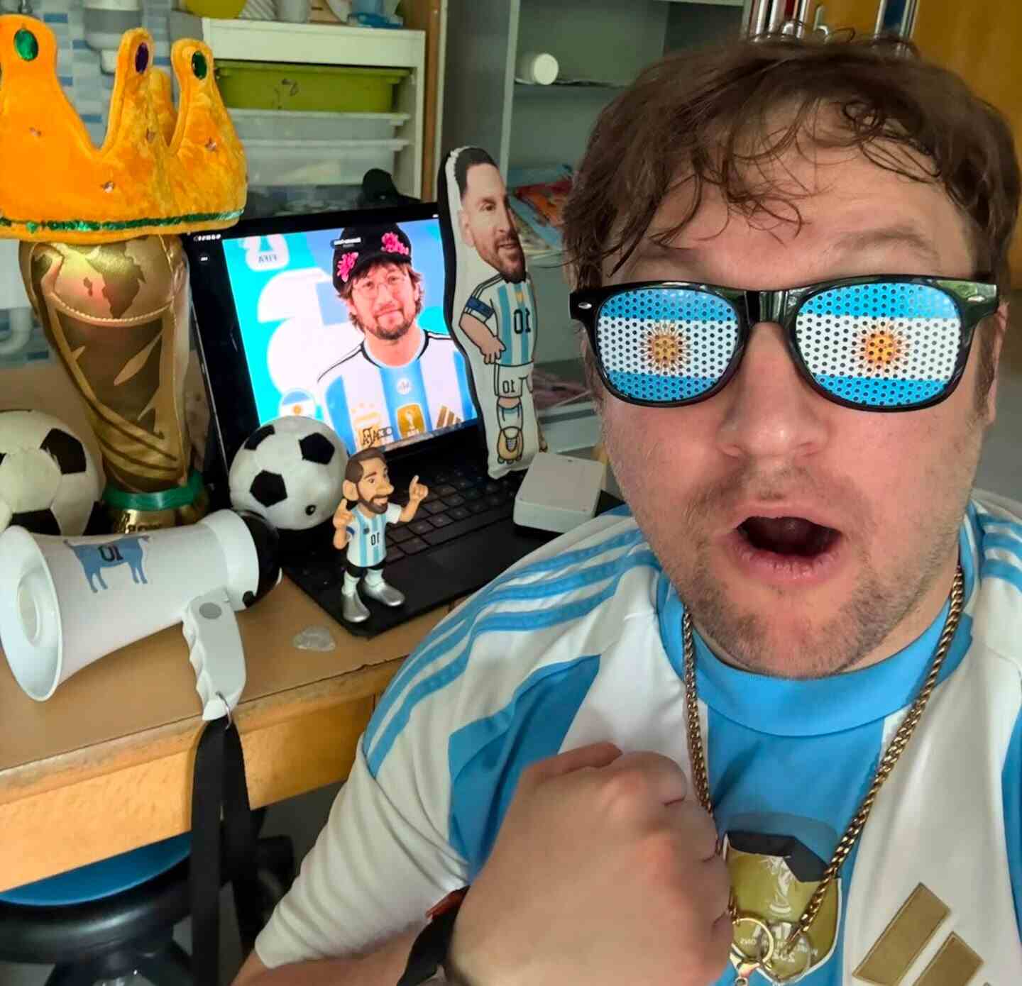 Axel Bernhard en su aula con elementos futbolísticos y un ordenador, transmitiendo su pasión por el rock argentino
