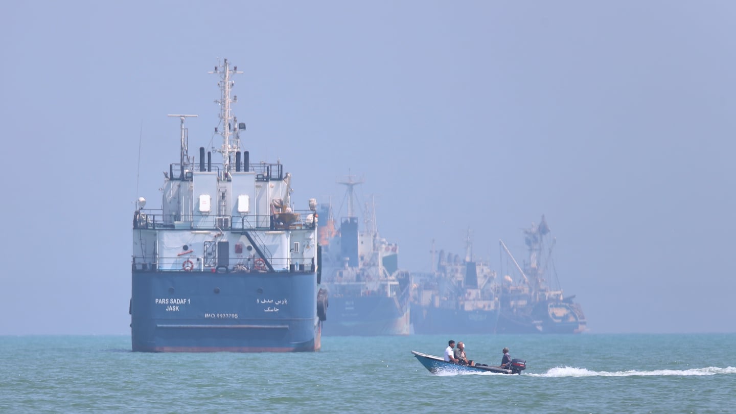 Barco de carga en el estrecho de Ormuz con una embarcación pequeña en primer plano