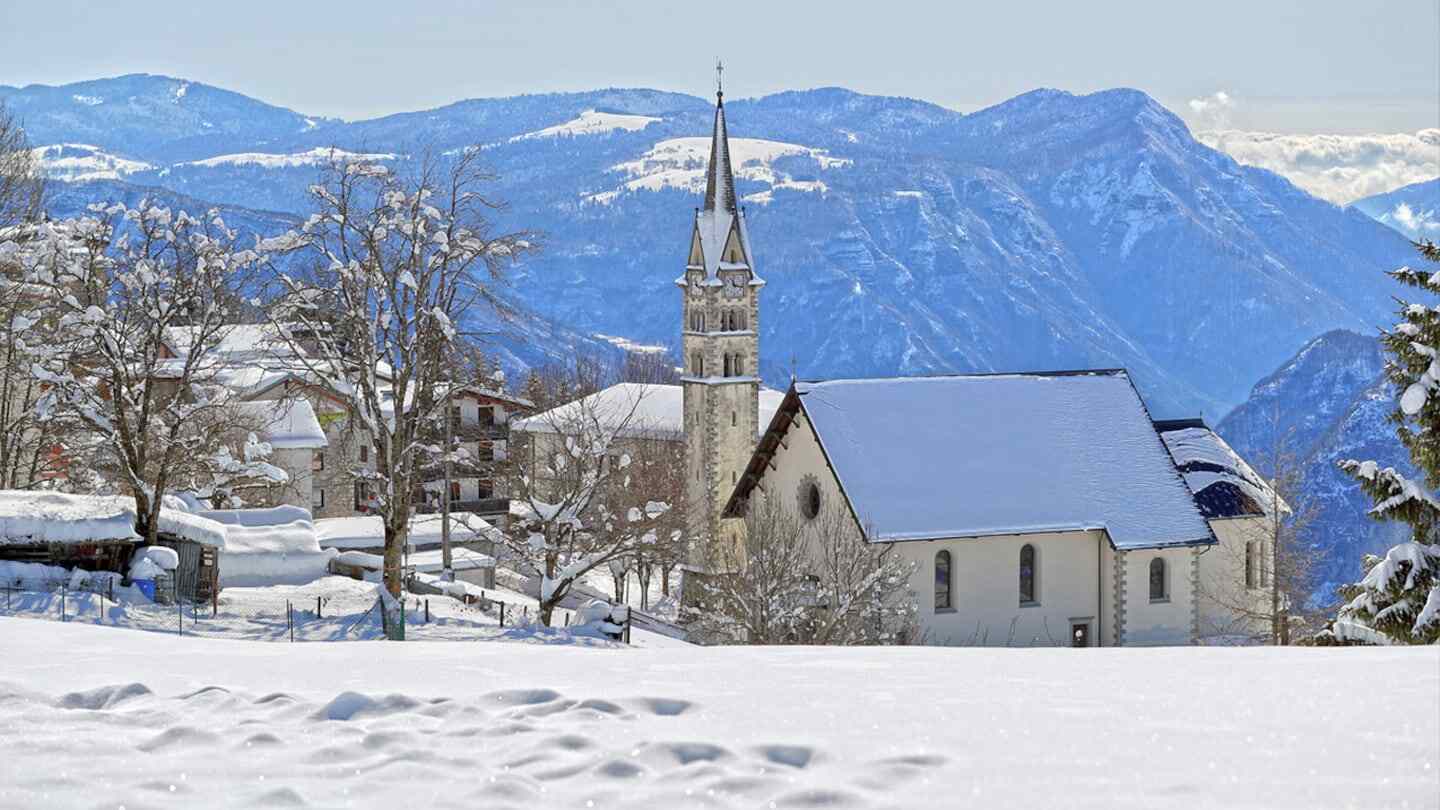 Vista invernal del pueblo de Luserna en Italia con montañas al fondo