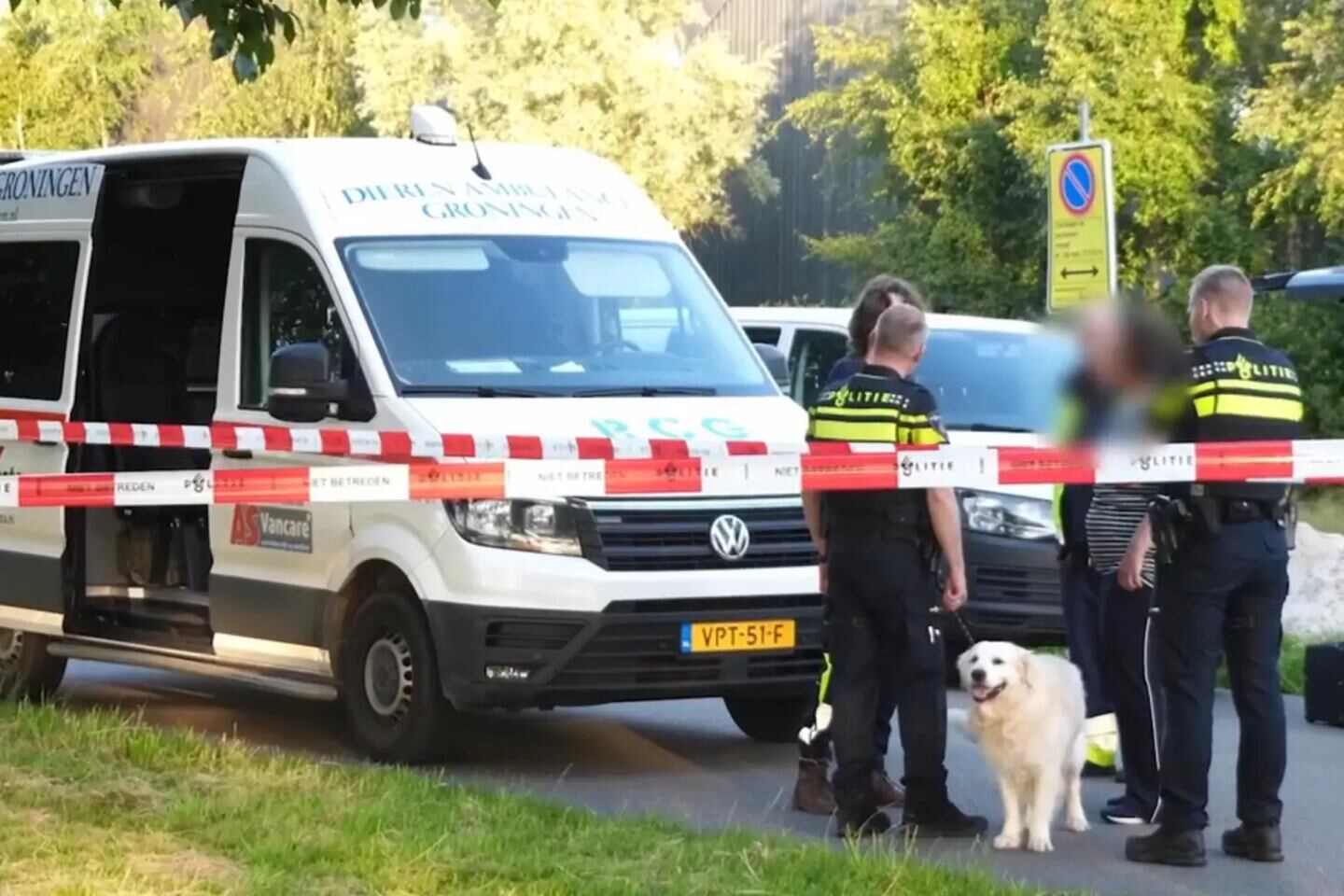 Policías en la escena del crimen en Groningen, Países Bajos, con un perro y un vehículo de emergencia