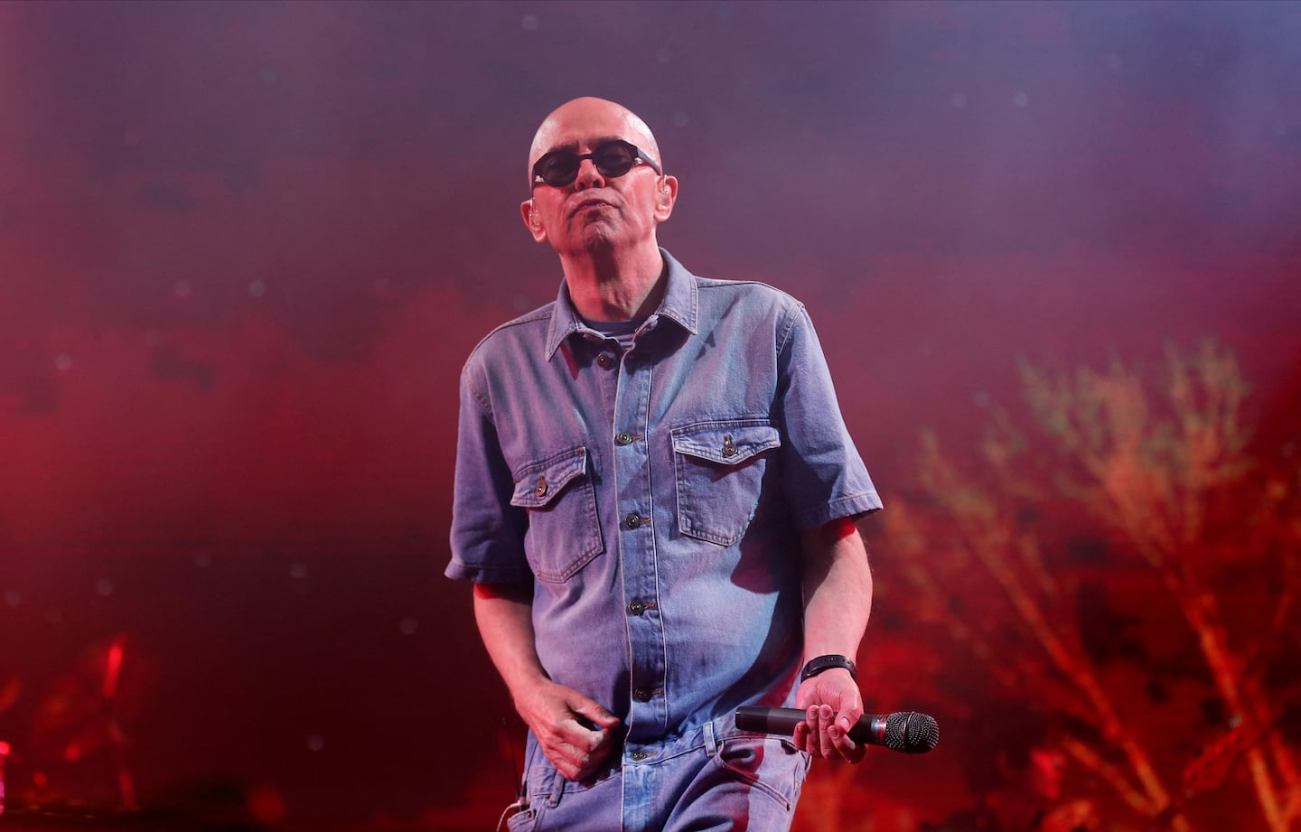 Indio Solari en concierto con gafas de sol y atuendo de denim