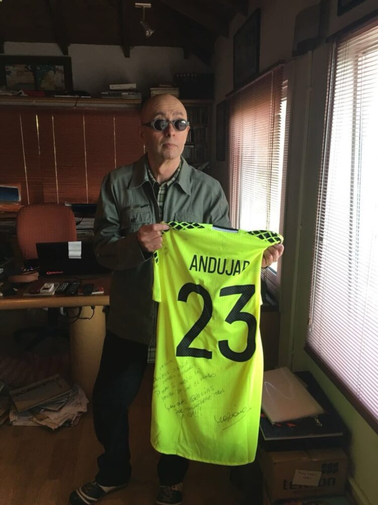 Indio Solari sosteniendo una camiseta firmada de Mariano Andújar con el número 23