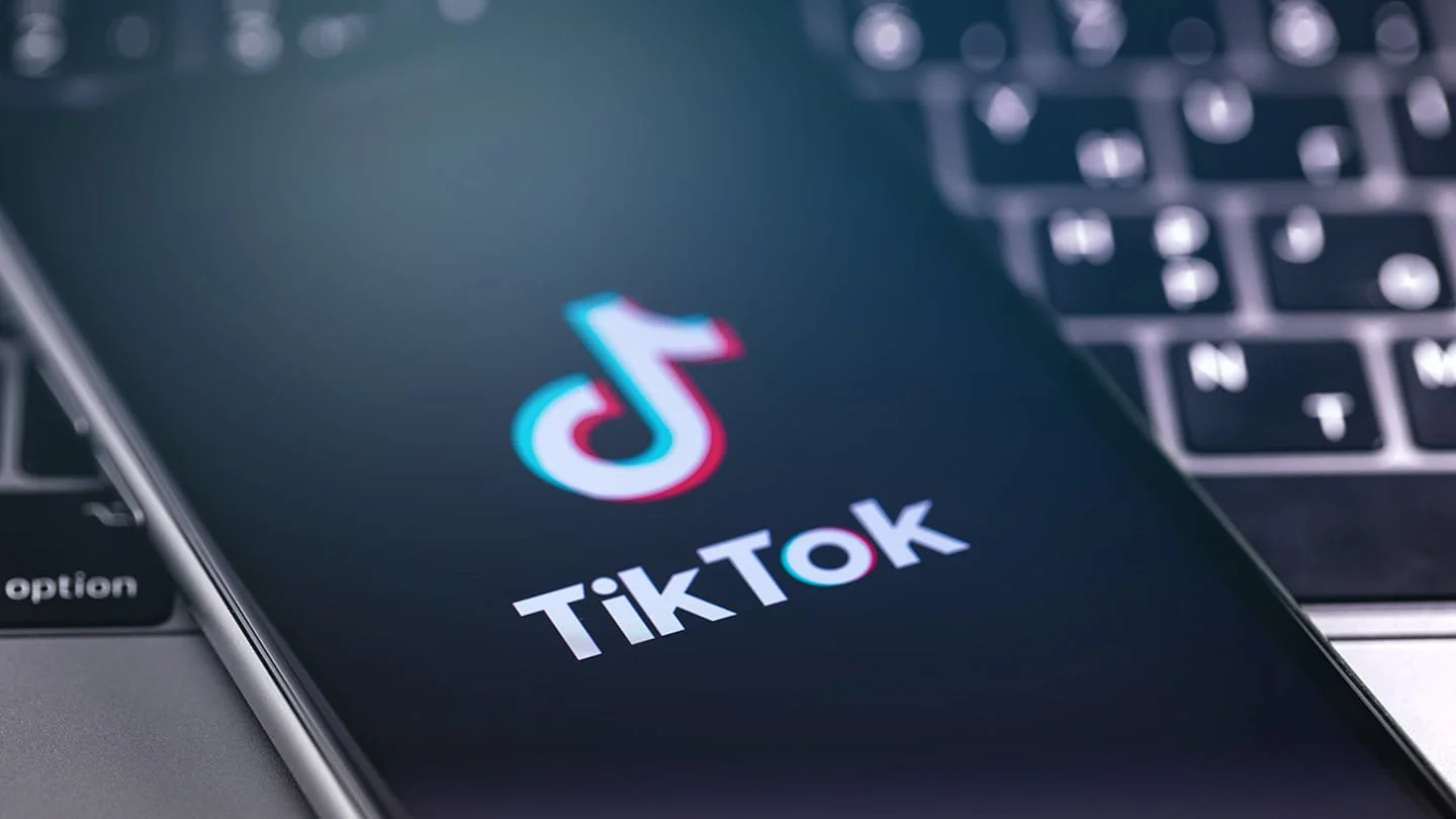 Logotipo de TikTok en un teléfono móvil sobre un teclado de computadora