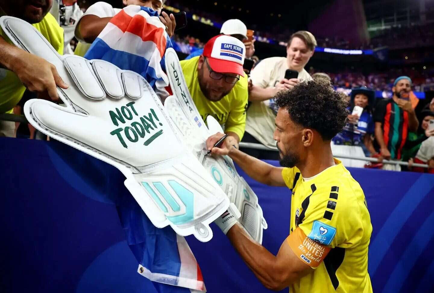 Vozinha, el arquero de Cabo Verde, firma guantes en un evento deportivo
