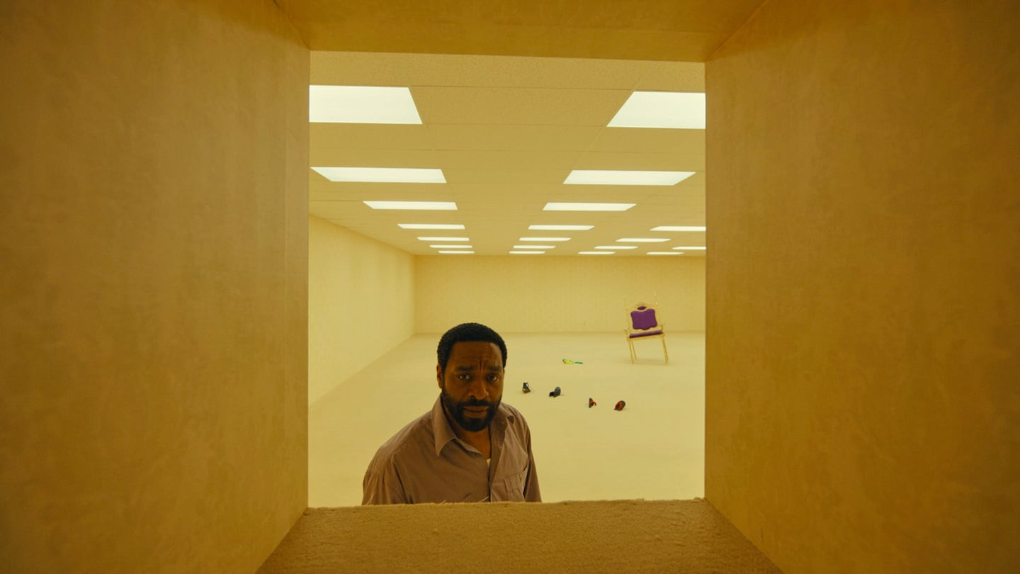 Hombre mirando a través de una ventana en un ambiente vacío y desolado