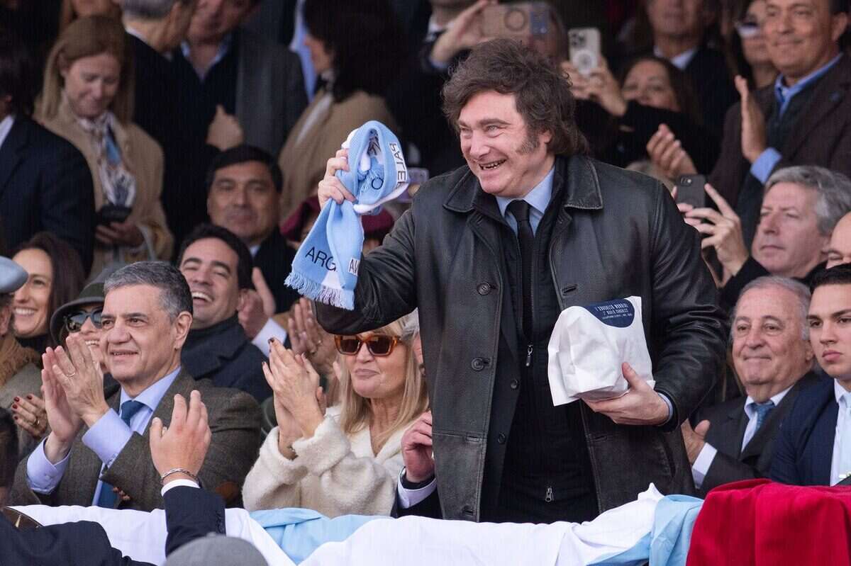 Javier Milei sostiene una bufanda en un evento político en Argentina