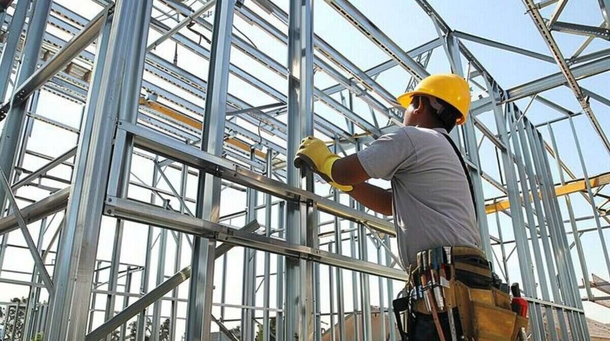 Trabajador de la construcción en obra con casco amarillo y herramientas