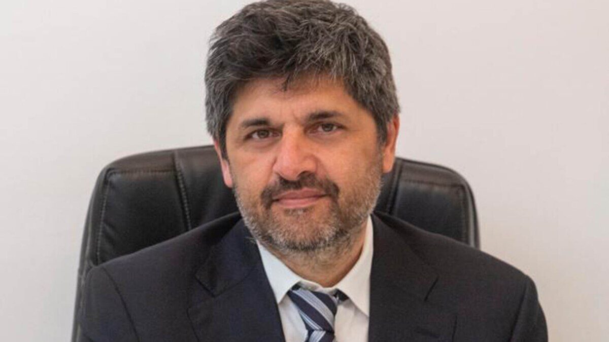 Retrato de un ejecutivo con barba y cabello canoso, sentado en una silla de oficina