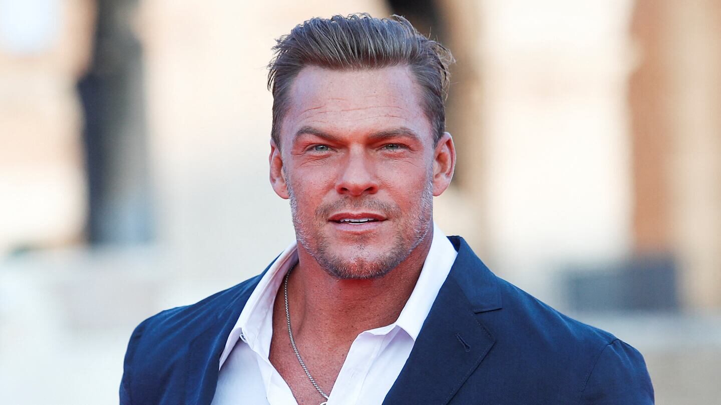 Alan Ritchson en un evento público con una expresión seria