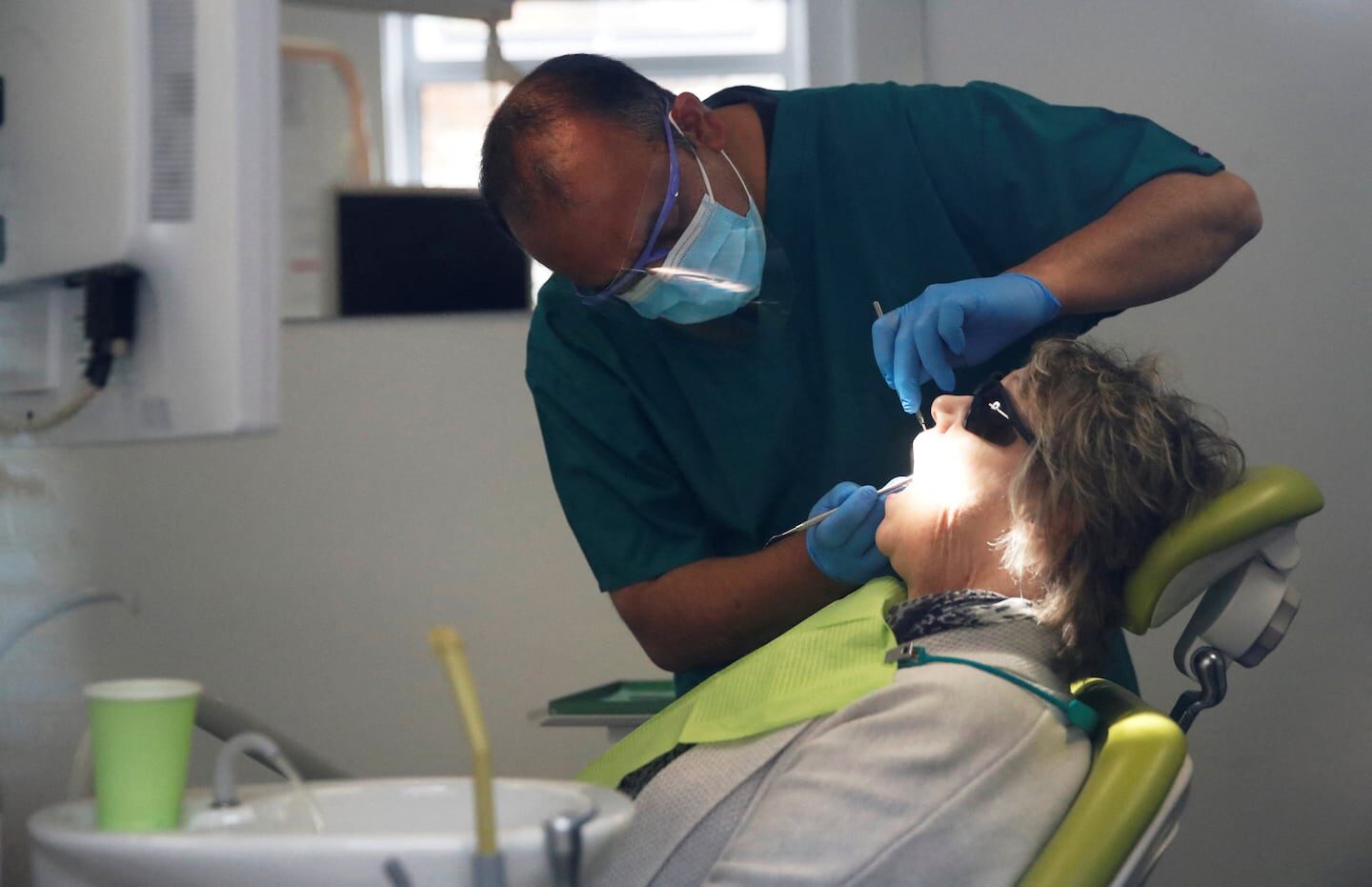 Odontólogo realizando un chequeo dental a una paciente en consulta