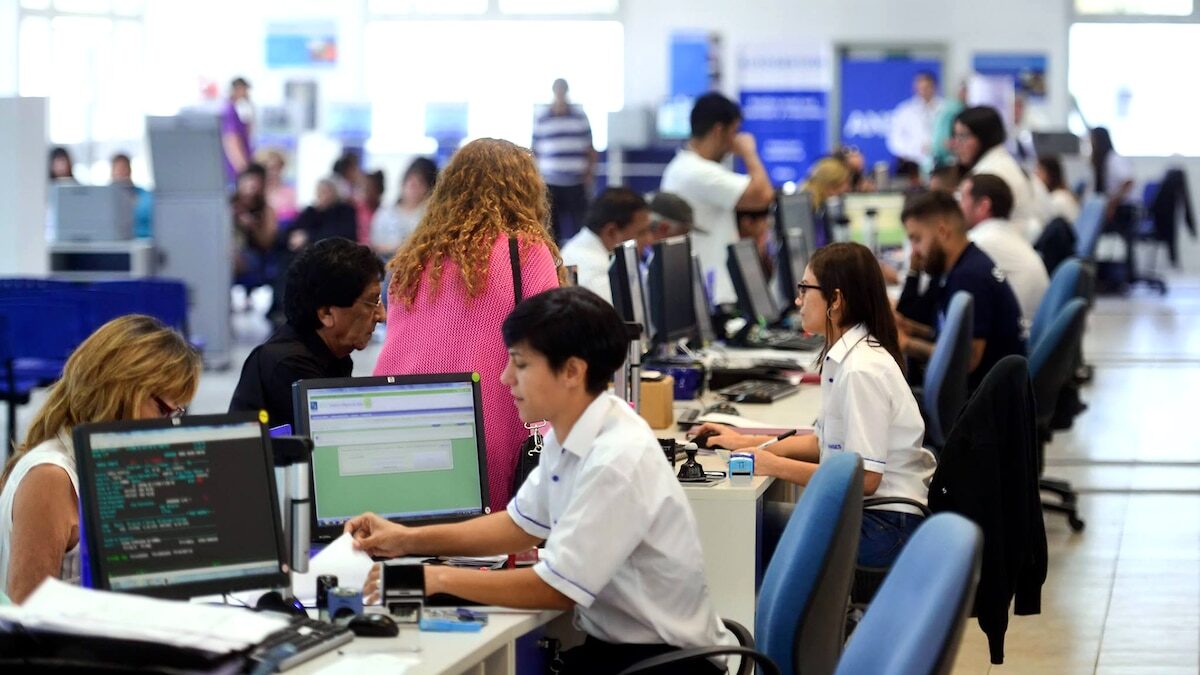 Oficina de ANSES con empleados atendiendo a beneficiarios en computadoras