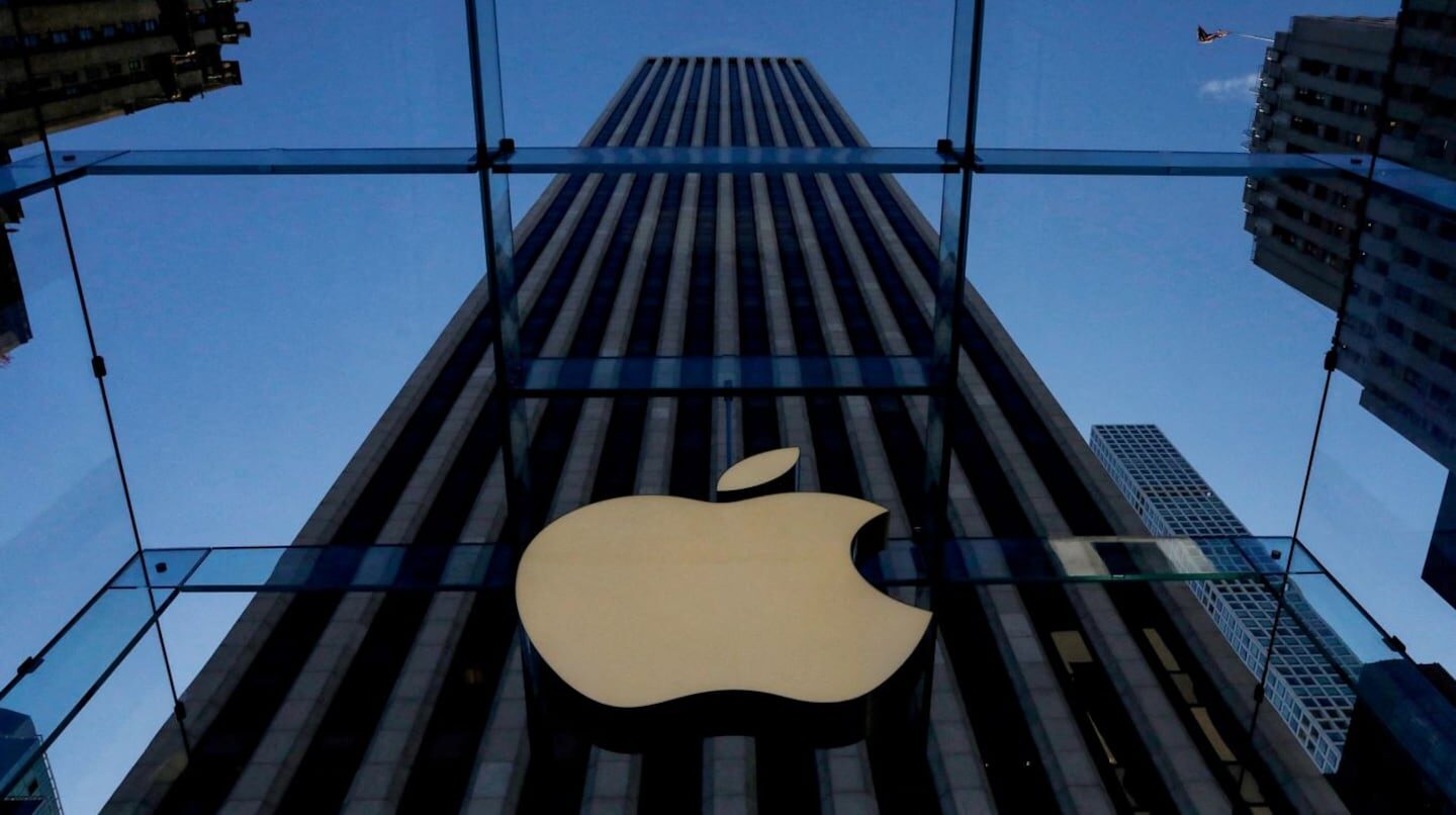 Logotipo de Apple en la entrada de una tienda con un edificio de fondo