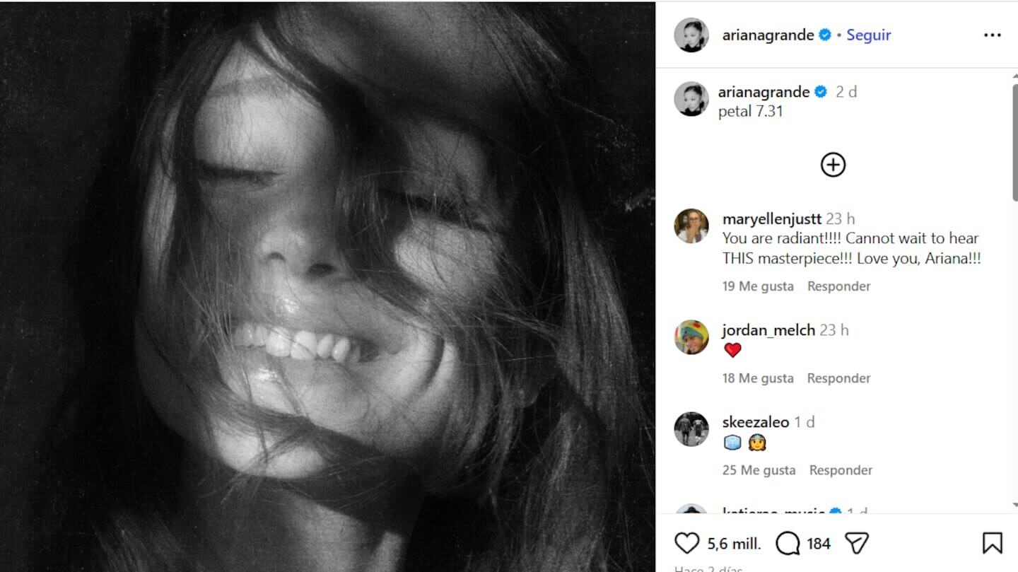 Ariana Grande sonriendo con el cabello al viento en una imagen en blanco y negro