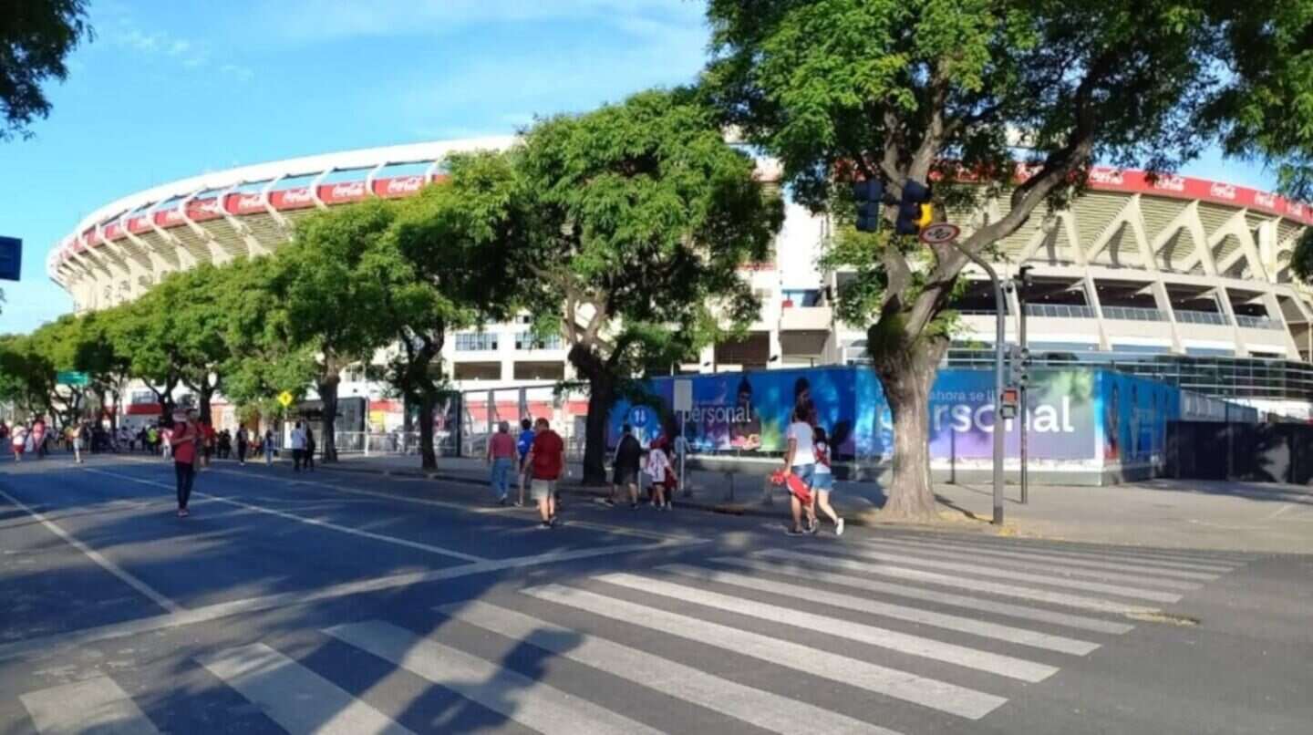 Vista del estadio de fútbol en Quilmes con personas cruzando la calle