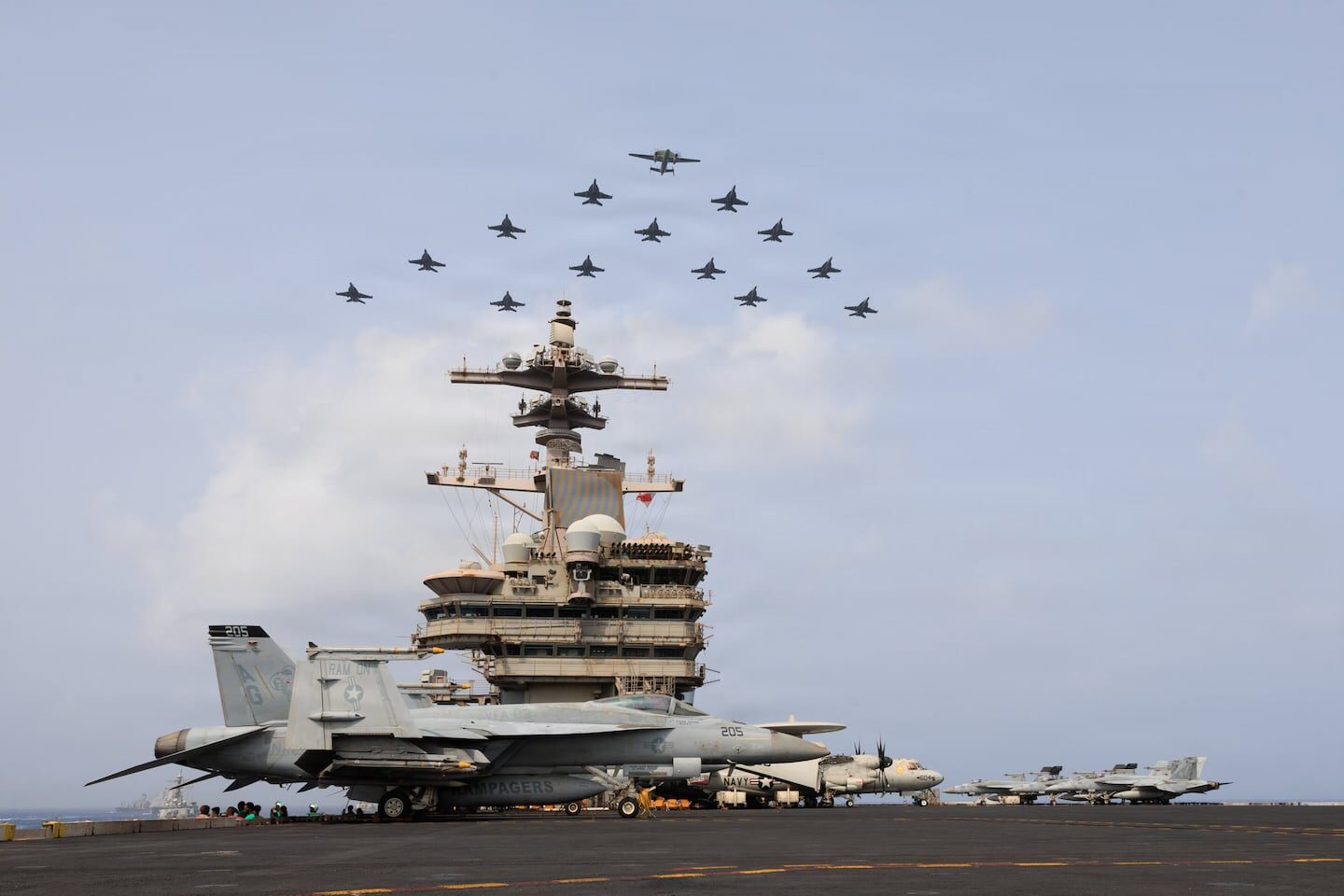 Portaviones estadounidense con aviones de combate en vuelo sobre él