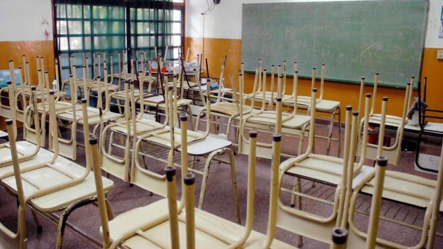 Aulas vacías con pupitres y sillas apiladas en un colegio privado de Buenos Aires