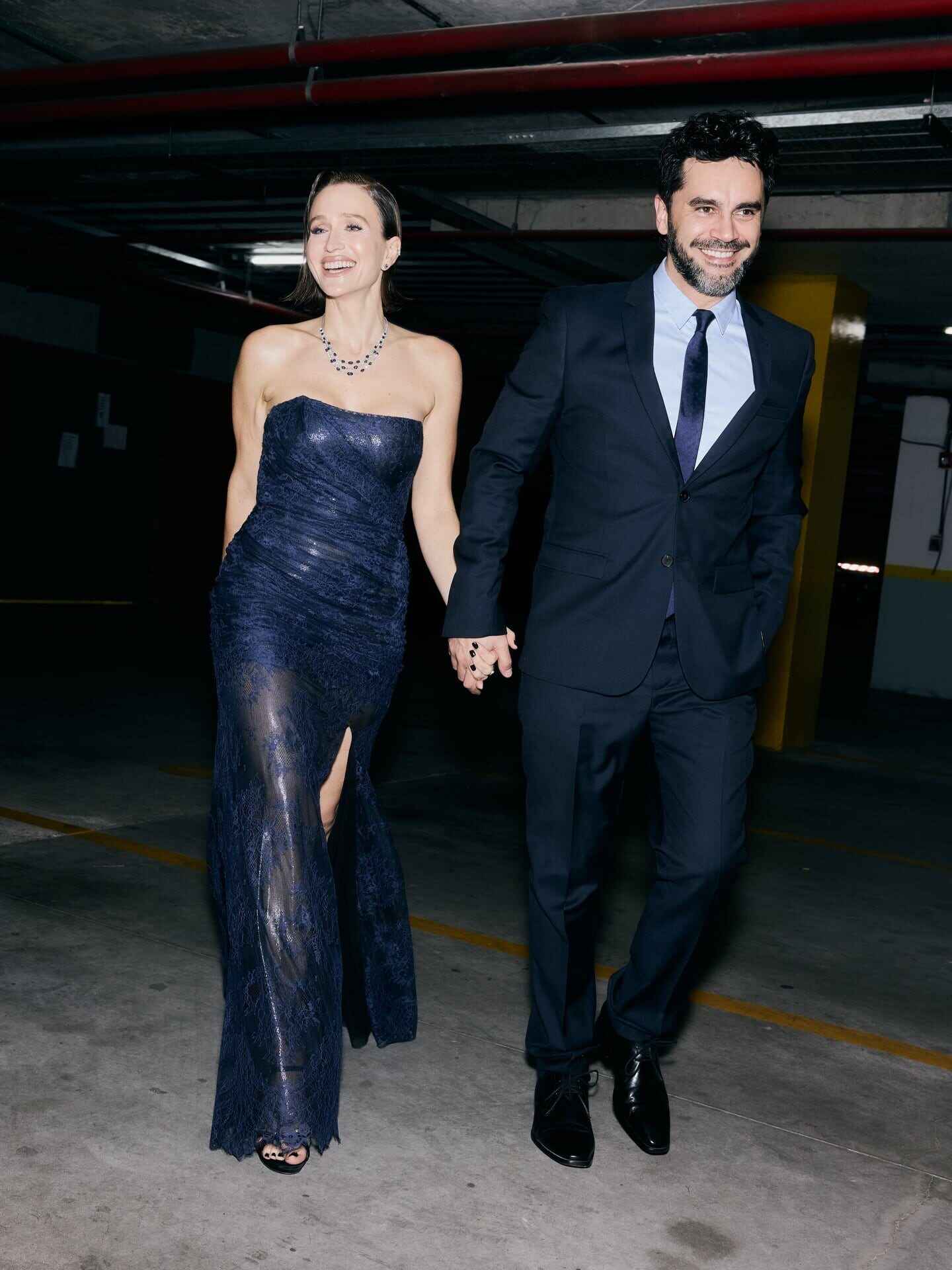 Brenda Gandini y Gonzalo Heredia caminando de la mano en el Teatro Colón con elegantes trajes azules