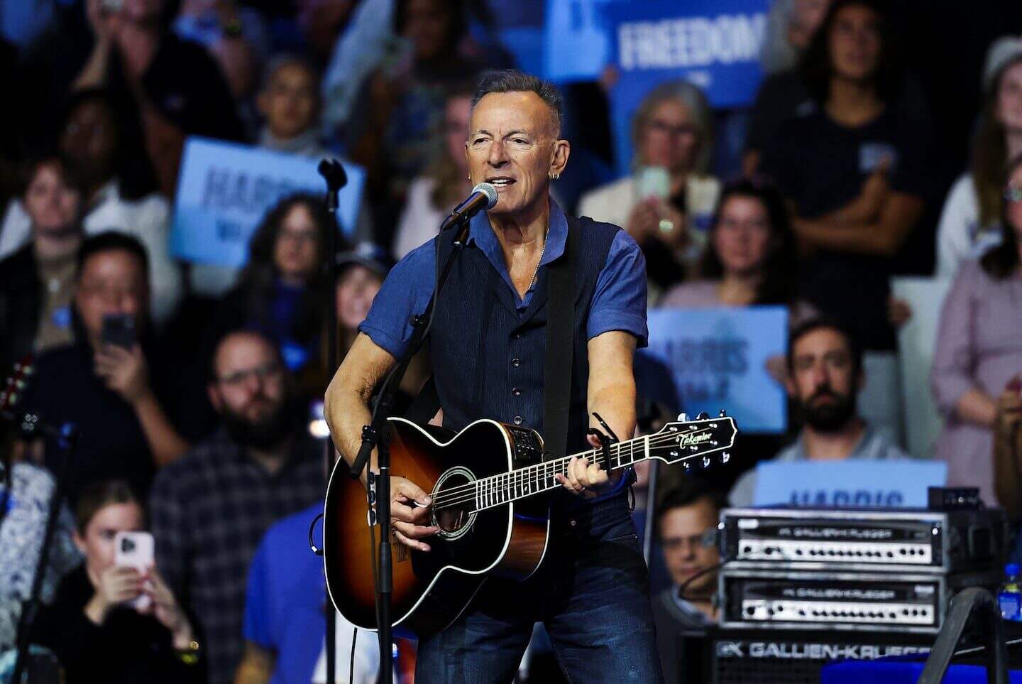 Bruce Springsteen tocando la guitarra en un concierto frente a un público entusiasta