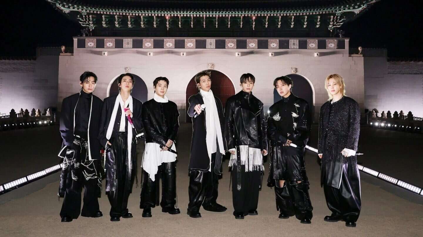 BTS posando en un evento nocturno frente a un palacio tradicional