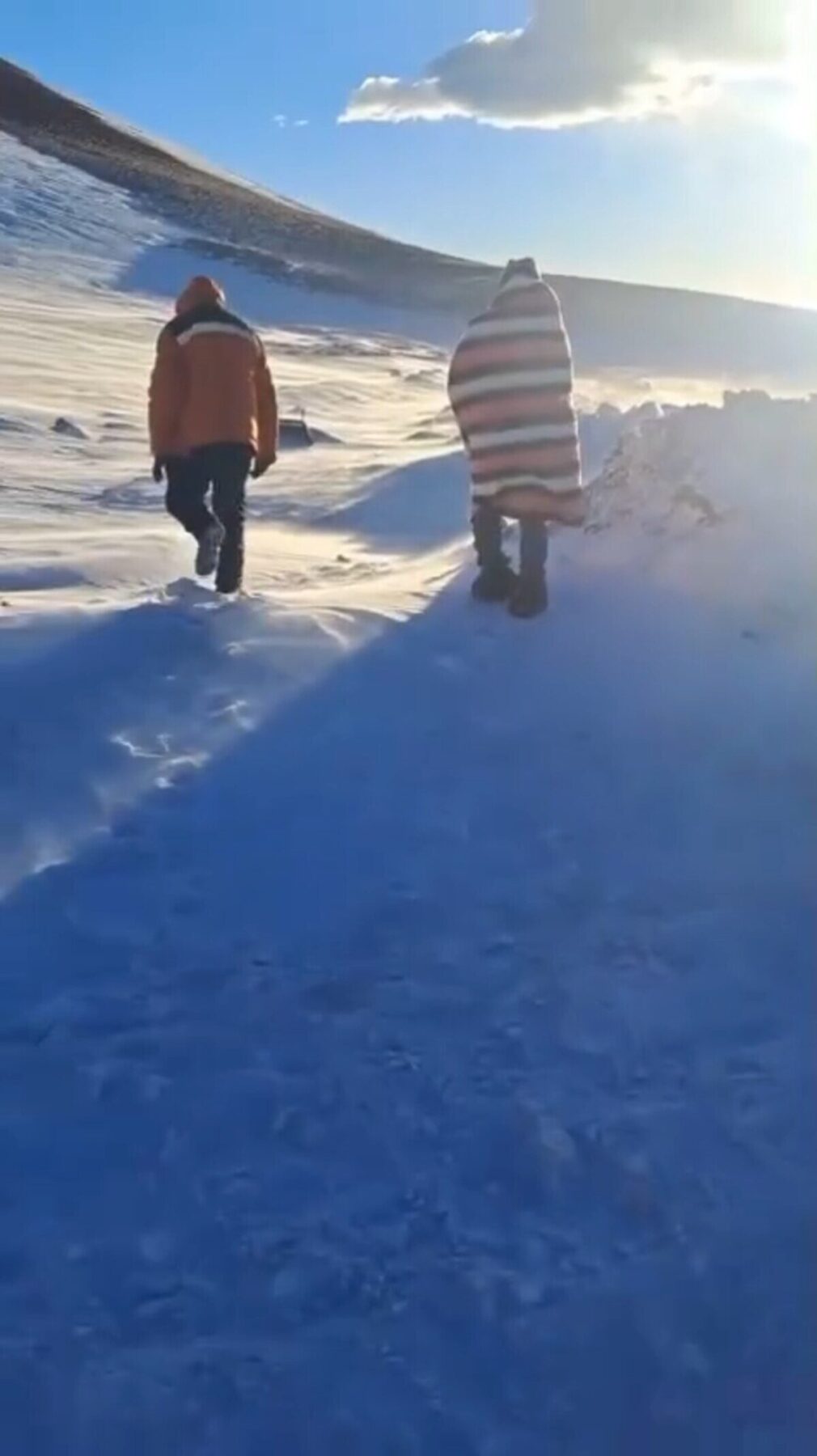 Dos personas caminando en un paisaje nevado en Catamarca