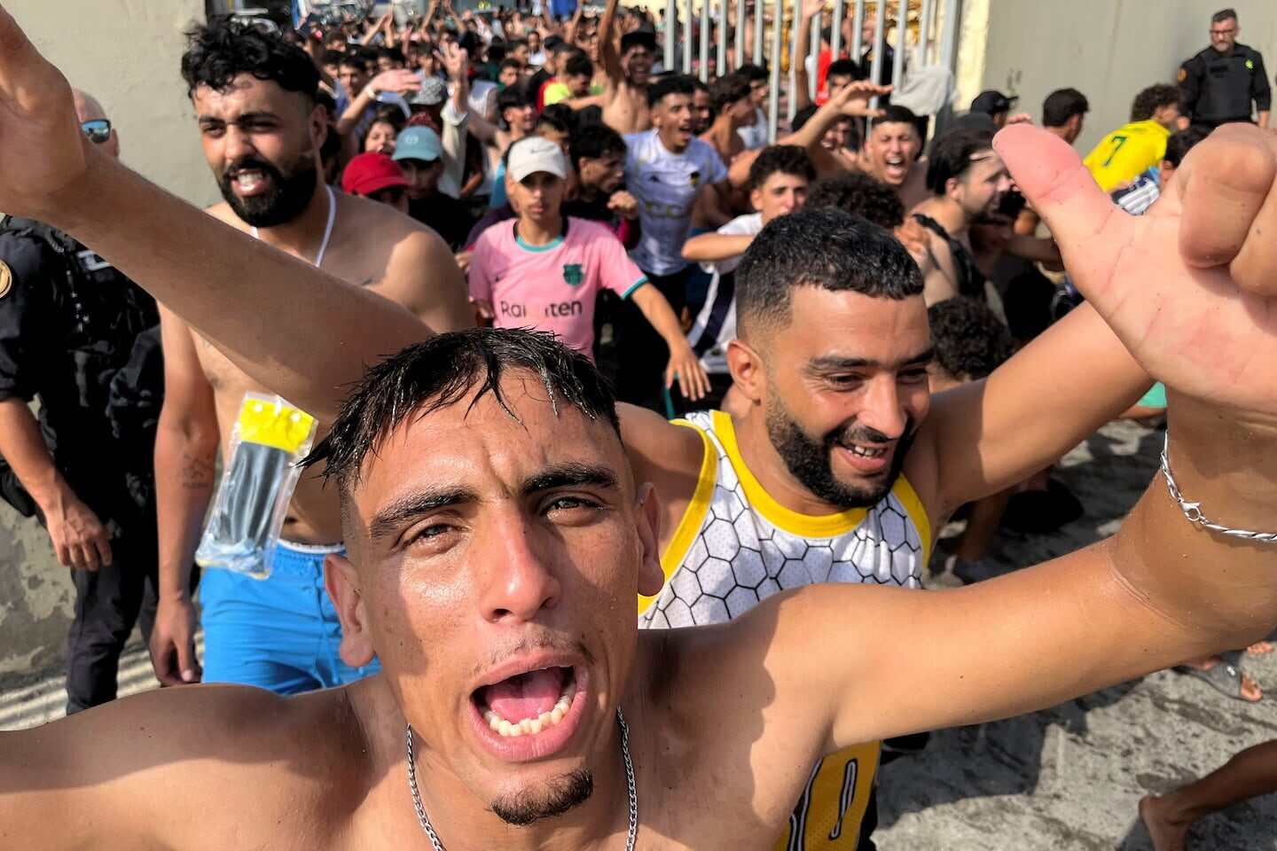 Grupo de migrantes celebrando en la frontera de Ceuta con Marruecos