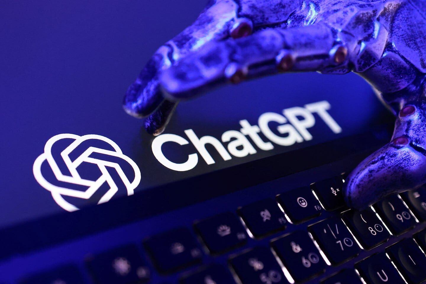 Mano robótica sobre el logo de ChatGPT en un teclado
