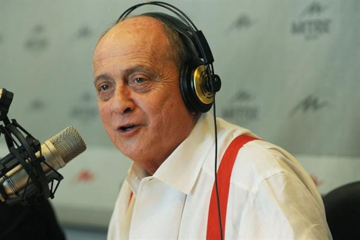 Chiche Gelblung hablando en un micrófono con auriculares en un estudio de radio