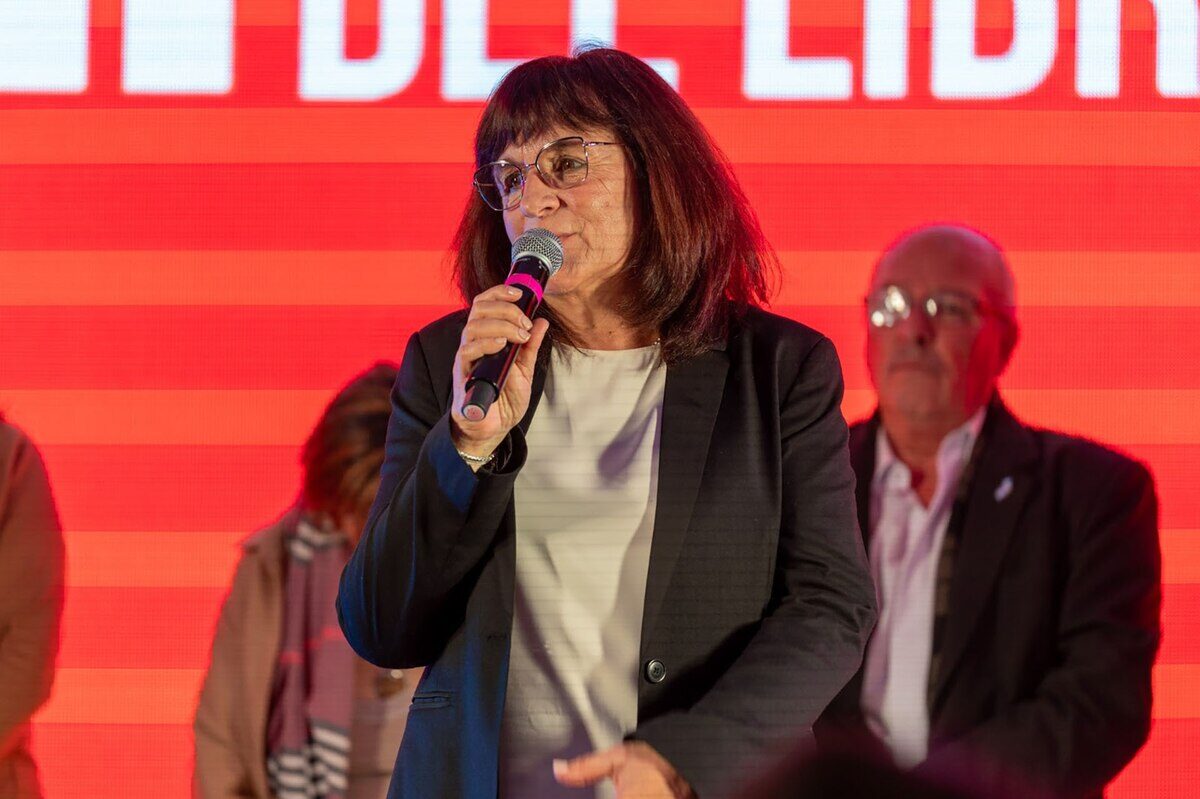 Mujer hablando con micrófono en un evento relacionado con la Feria Internacional del Libro en Comodoro Rivadavia