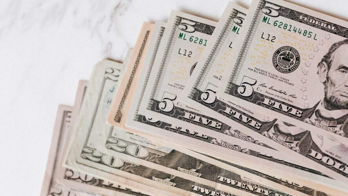Billetes de dólar estadounidense en diferentes denominaciones sobre una superficie clara