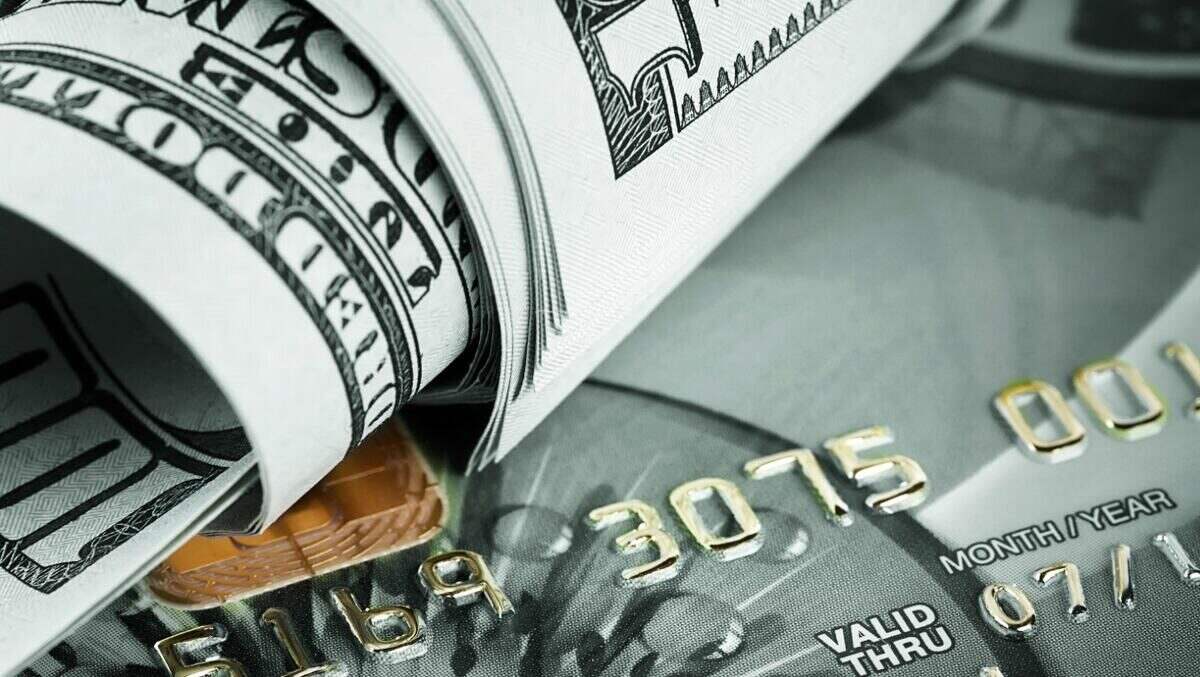 Billetes de dólar y tarjeta de crédito sobre fondo gris